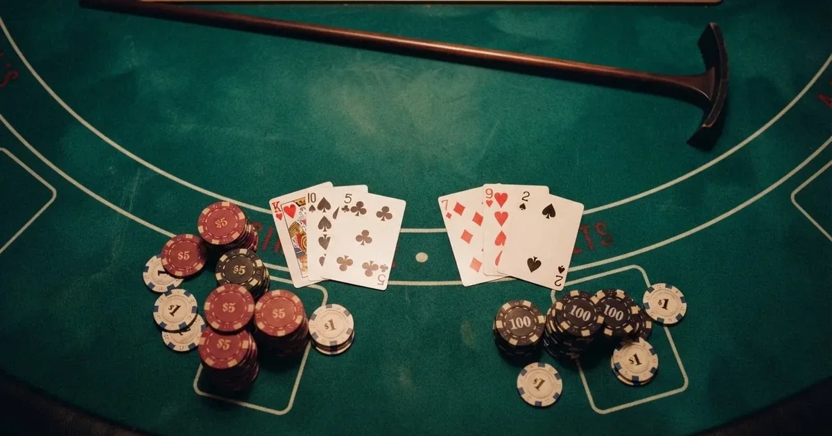 Tavolo da gioco illuminato con carte e fiches visto dall'alto — casino dal vivo online